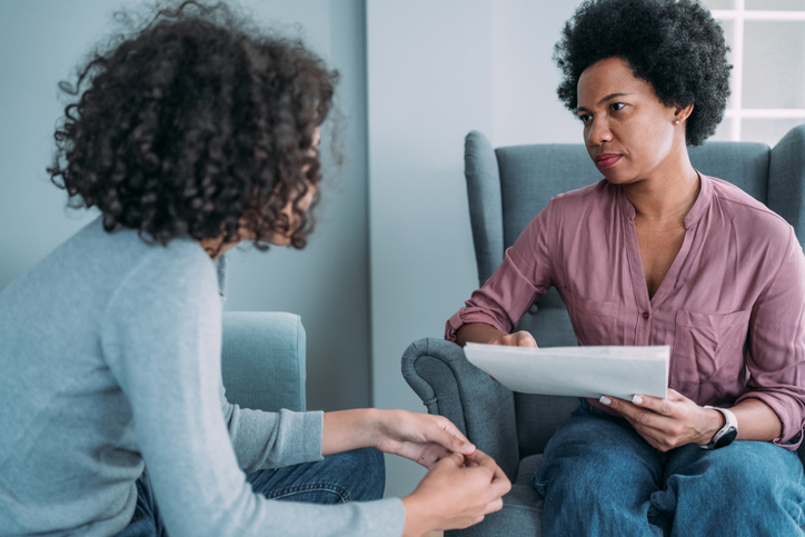 Female psychologist talking with teenage boy in her office. shift from survival mode
