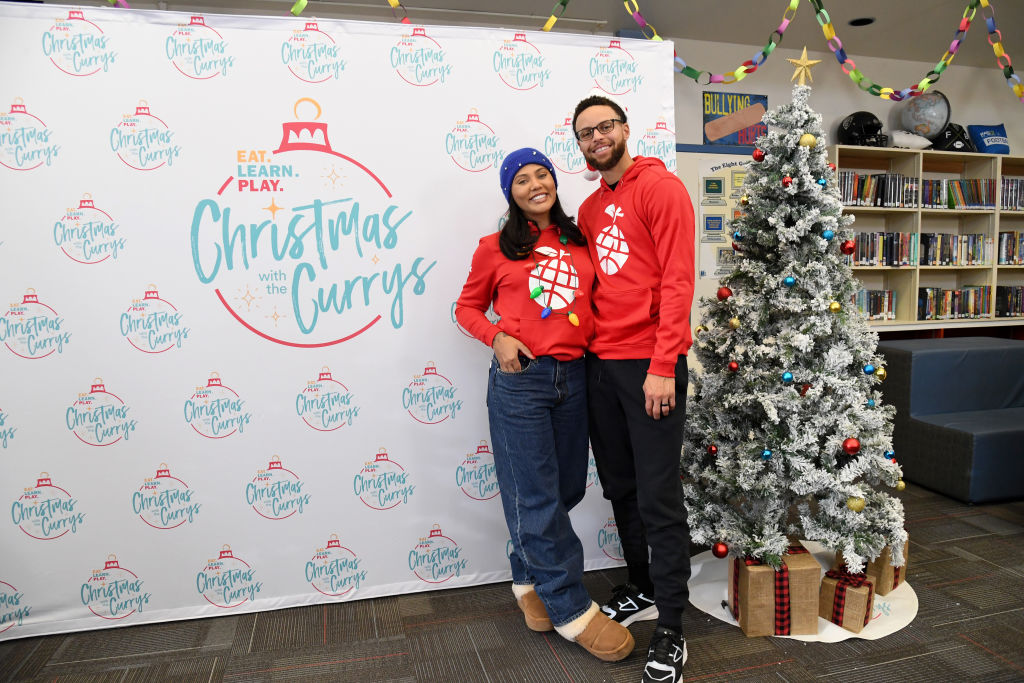 ayesha and steph curry posing in christmas sweaters