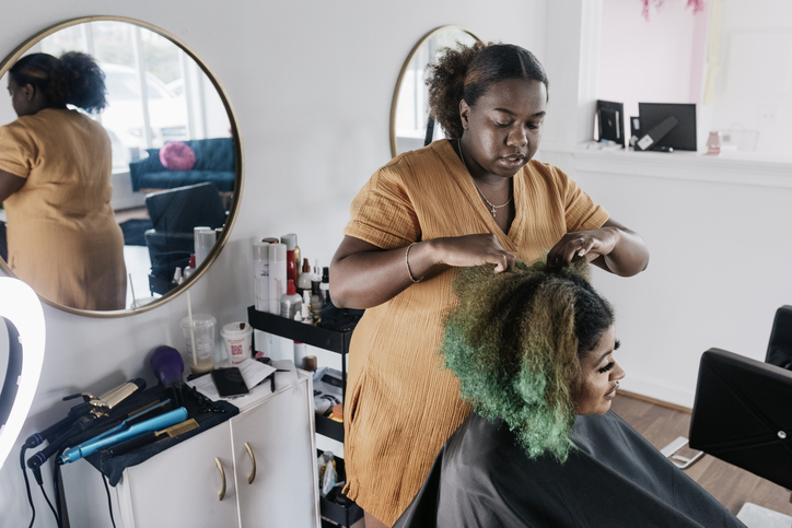 Black Hairdresser Preparing Client's Hair Before Cutting And Styling