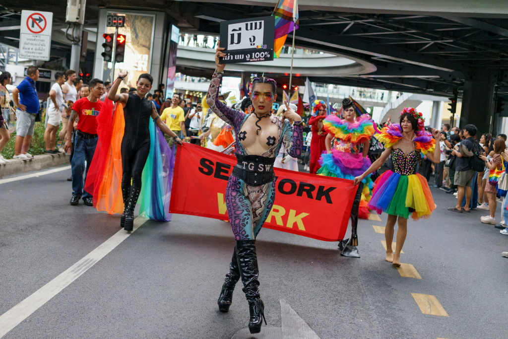 Sex worker holds a placard saying "Have boobs, Have snake (...