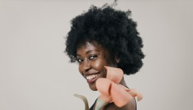 Beautiful Young Black Woman With Afro Hairstyle Taking Care of Skin