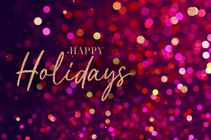 Happy Holidays Christmas Calligraphy Script Text. Christmas Gold Glitter Blured Bokeh Light Red Background. Happy Holidays text with sparkling gold letters on a vibrant red and pink bokeh background.