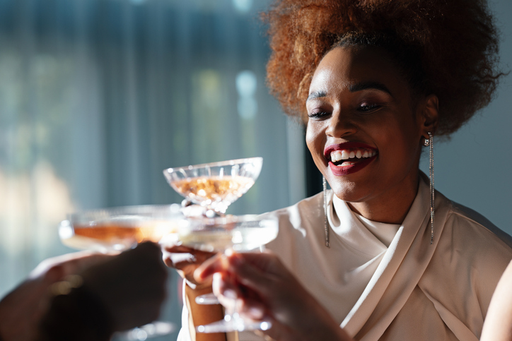 Smiling Woman Toasting With A Glass Of Wine During A New Year Celebration