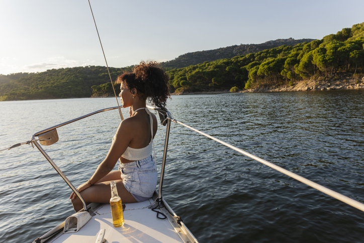 Woman enjoying leisure time on sailboat watching sunset