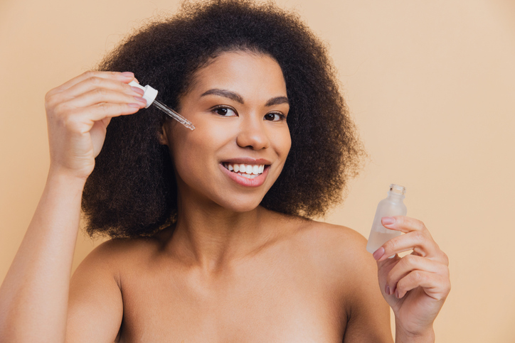 African American woman applying serum for skincare routine | Best Body Oil Products