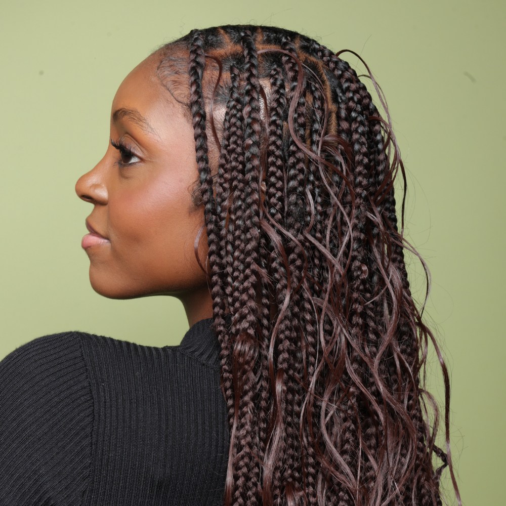 A side profile image of a model with boho braids