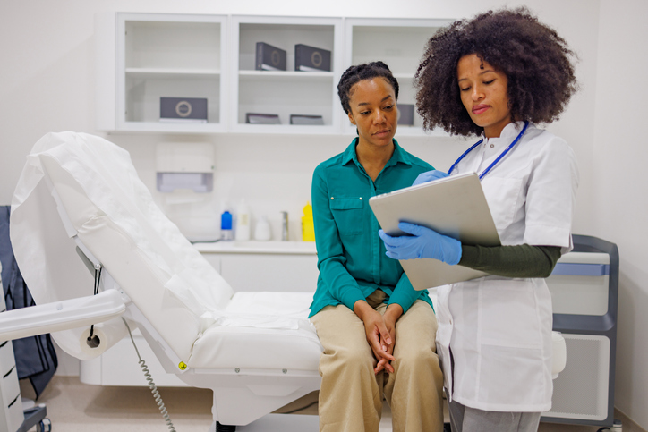 Doctor discussing medical information with patient using digital tablet during consultation in clinic