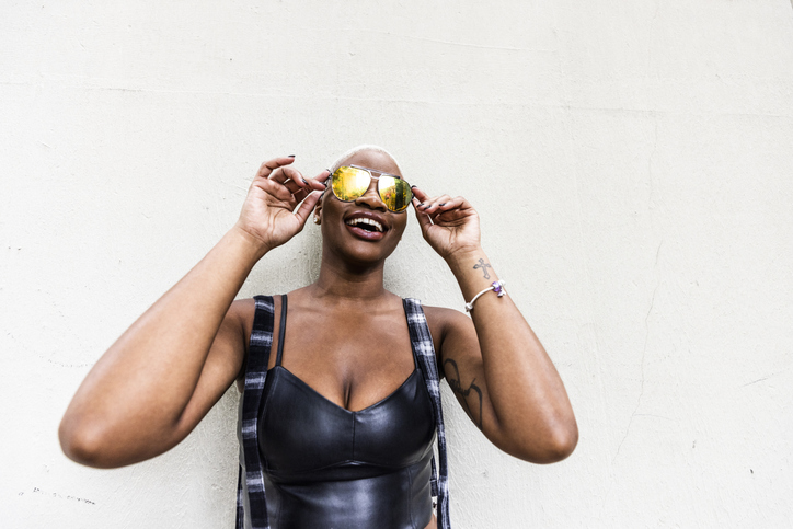 Fashionable female wearing aviator sunglasses on urban sidewalk