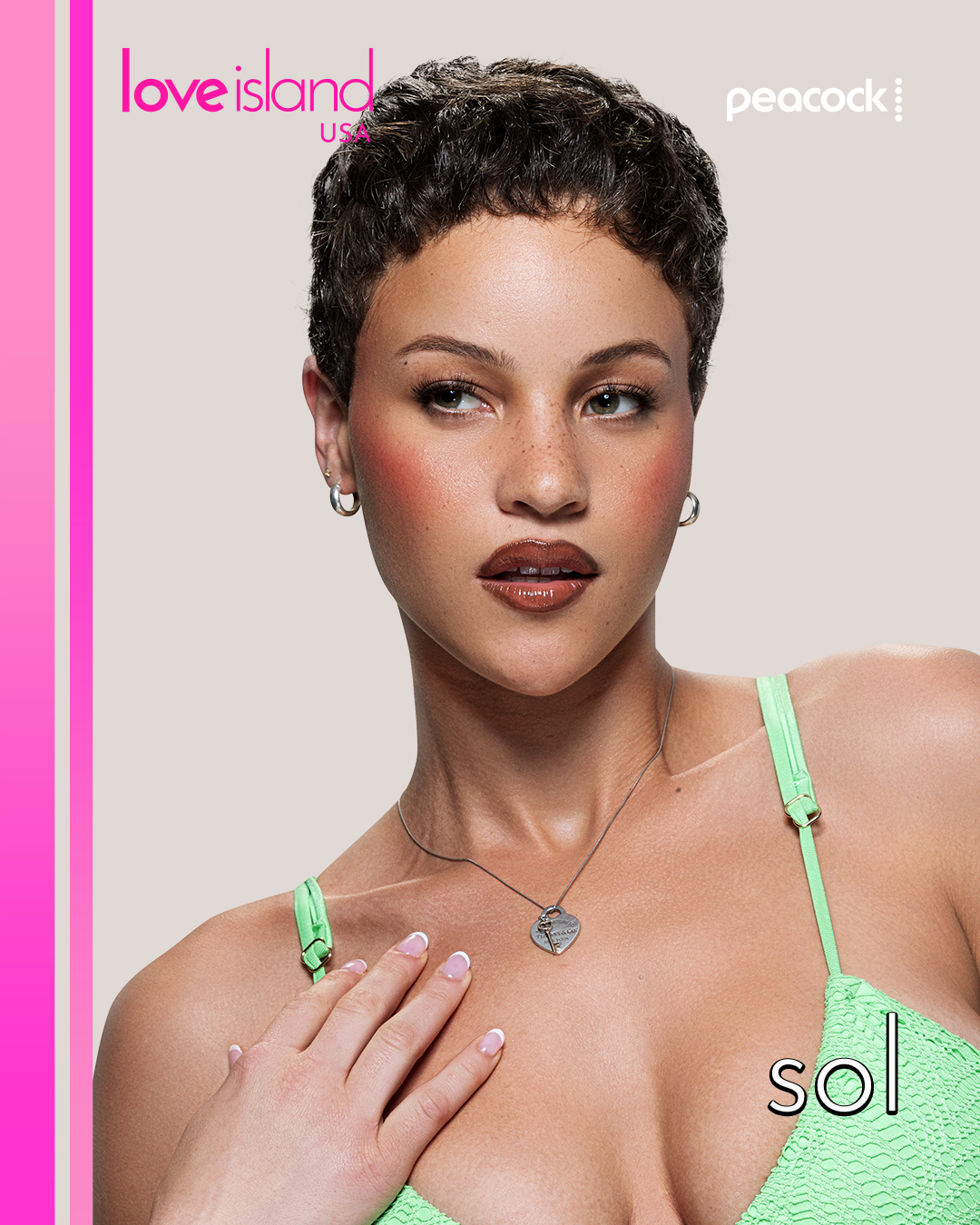 A woman with short dark hair wearing a green swimsuit top and necklace, looking directly at the camera against a pink background with "Love Island USA" and "Peacock" text.