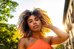 Young black woman posing outdoors with golden hour sunlight