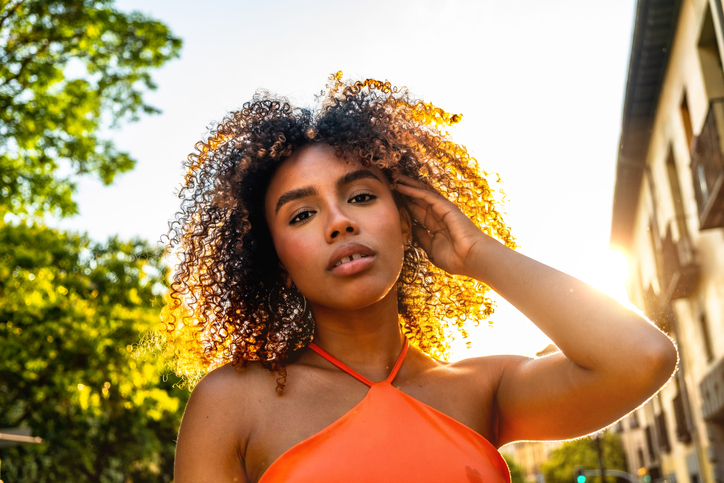 Young black woman posing outdoors with golden hour sunlight