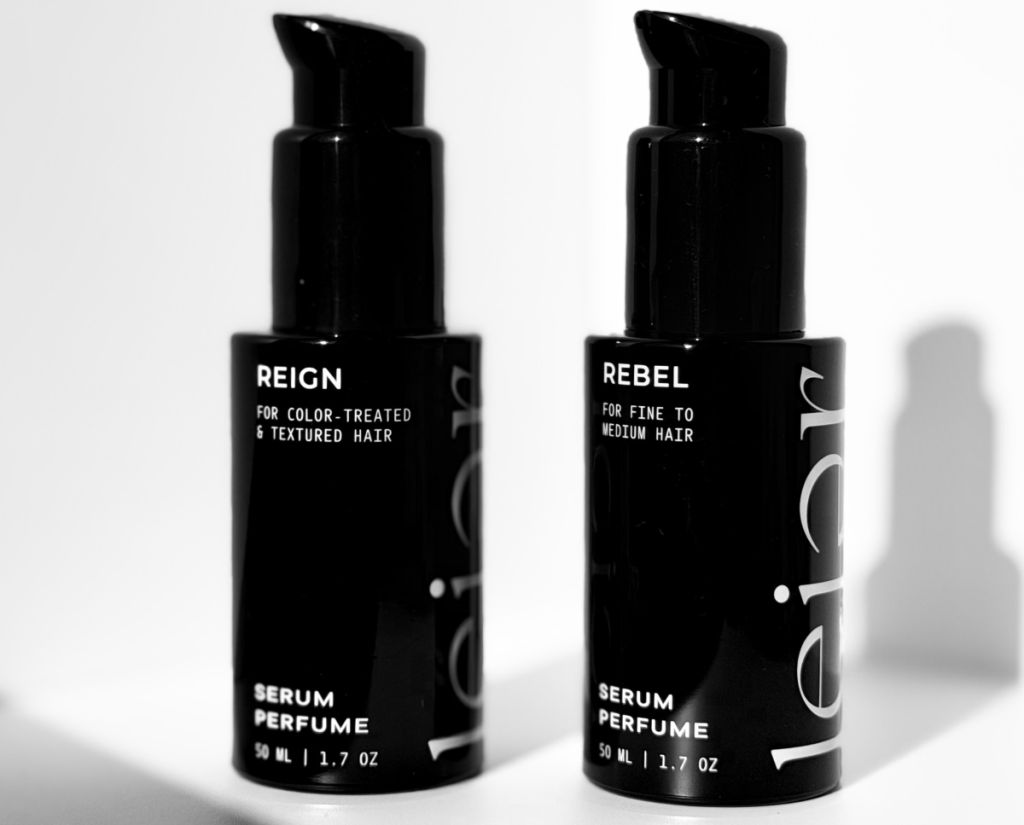Two black bottles labeled "Reign" and "Rebel" serum perfumes for color-treated and fine to medium hair.