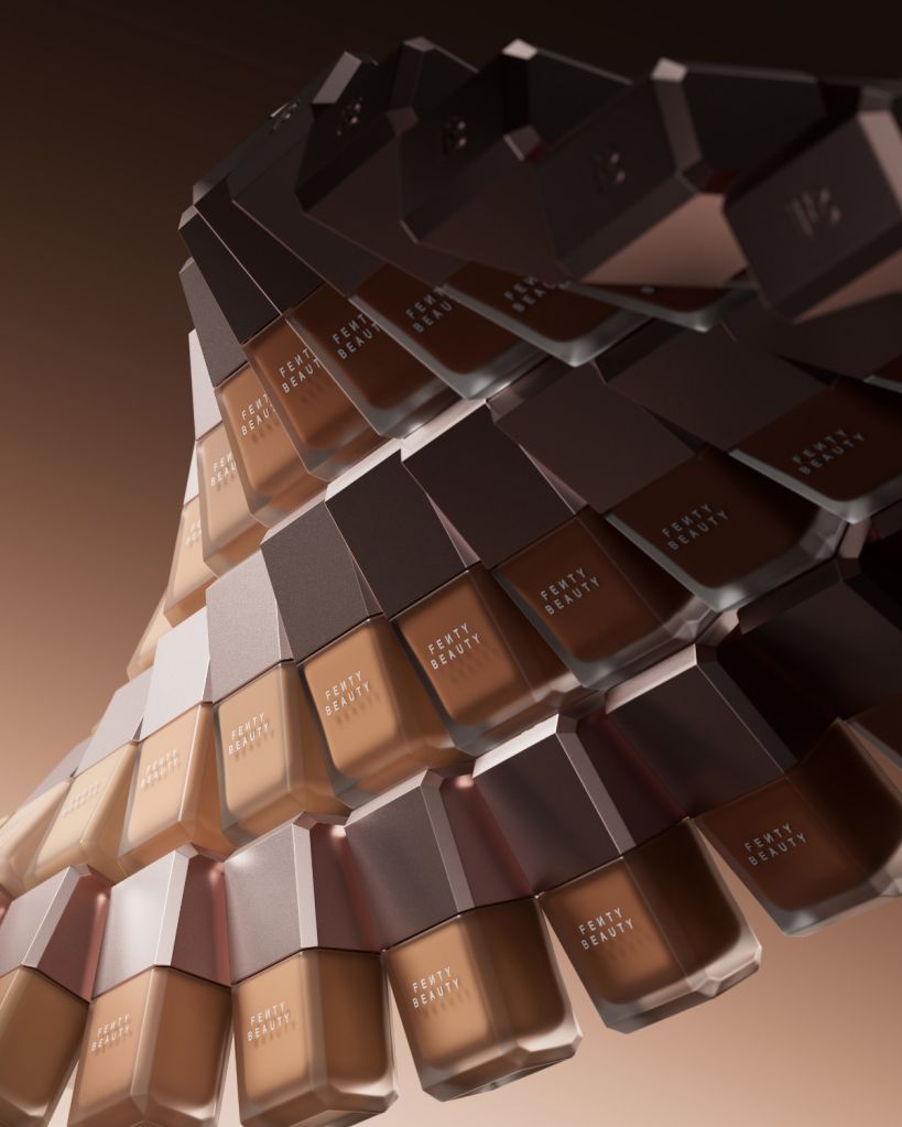 Stacked bottles of Fenty Beauty cosmetic products in various shades of foundation.